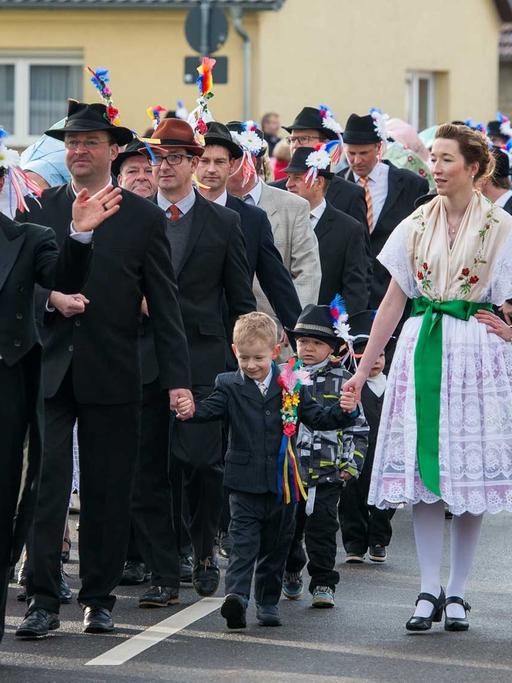 Paare in original sorbischer Festtagstracht gehen am 06.02.2016 beim traditionellen Zapust, der sorbisch-wendischen Fastnacht, durch den Ort Jänschwalde