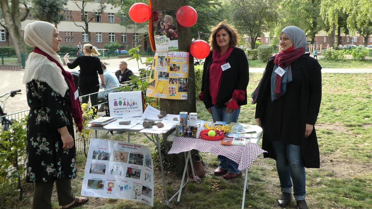 Mehrere Frauen stehen vor einem Tisch in einem Park. Auf dem Tisch liegt Informationsmaterial. Mehrere Frauen stehen vor einem Tisch in einem Park. Auf dem Tisch liegt Informationsmaterial.