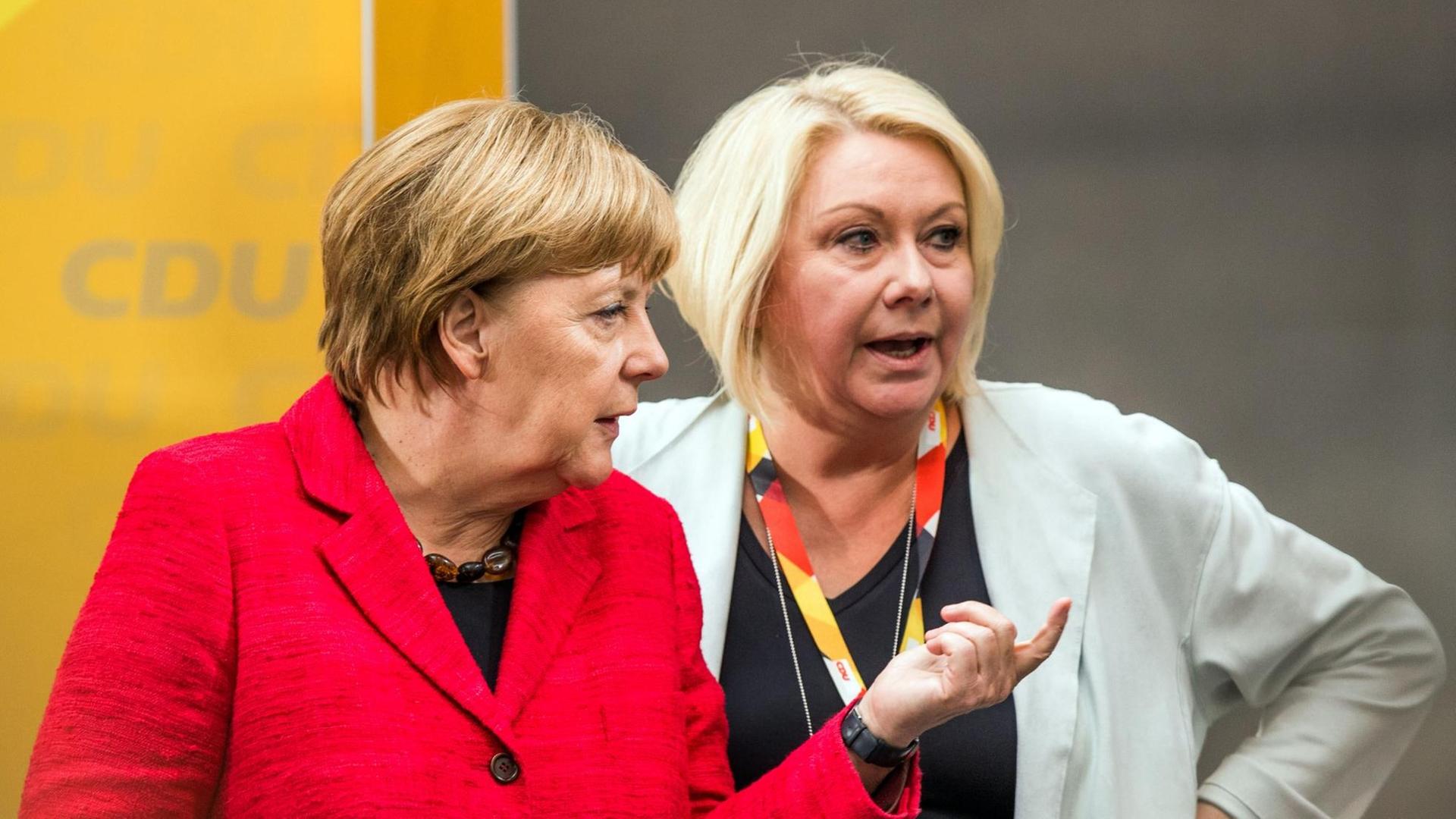 Bundeskanzlerin Angela Merkel (CDU, l) und die CDU-Bundestagsabgeordnete Karin Strenz (r) sprechen am Rande eines Wahlkampftauftritts in Wismar (Mecklenburg-Vorpommern) miteinandern. Sechs Tage vor der Bundestagswahl kommt Merkel zu zwei Auftritten nach Mecklenburg-Vorpommern.