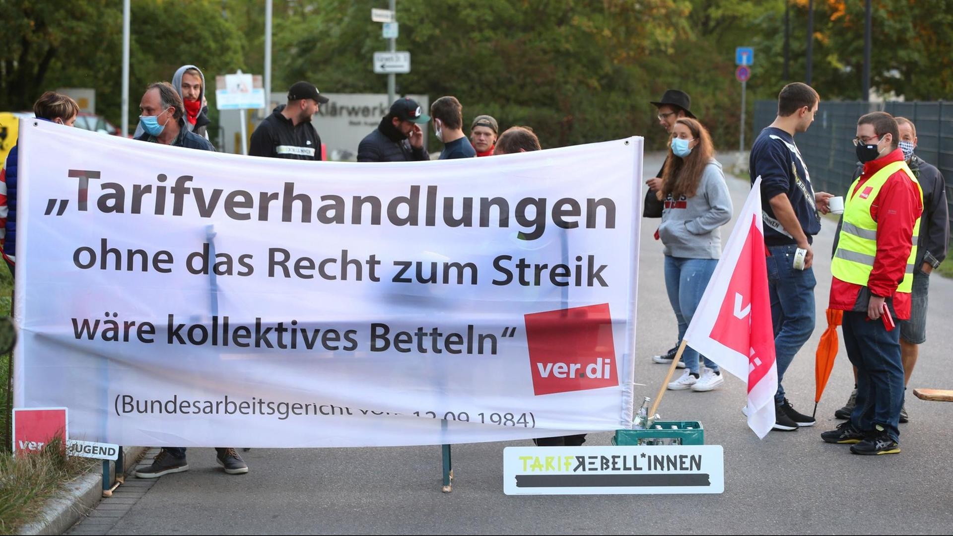 In Augsburg halten Mitarbeiter von der Stadt ein Transparent in den Händen.