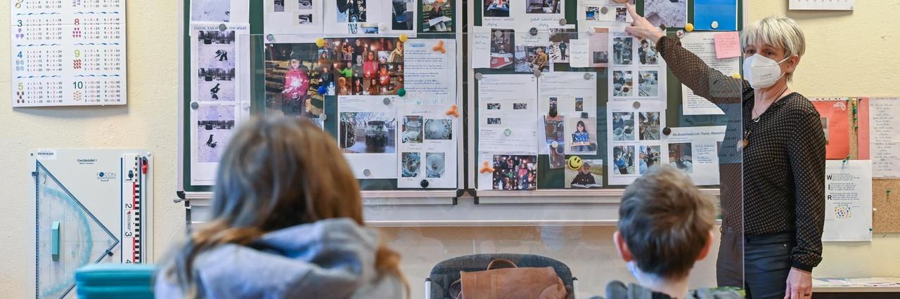 Unterrichtsszene: In einem Klassenzimmer sieht man zwei Kinder von hinten. Unterrichtsszene: In einem Klassenzimmer sieht man zwei Kinder von hinten.