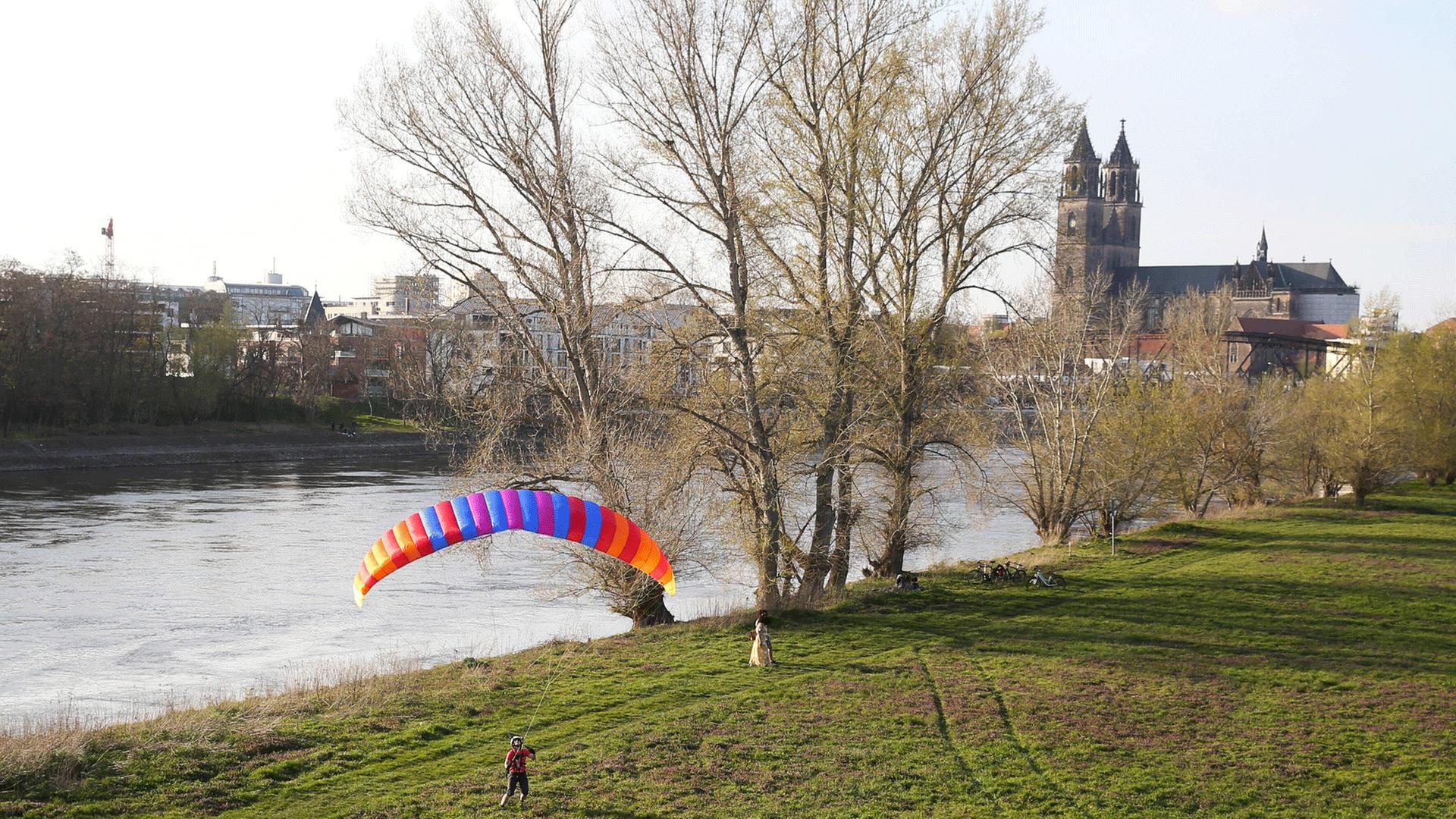 Auf den Elbwiesen versucht eine Frau mit einem Gleitschirm zu fliegen. Auf den Elbwiesen versucht eine Frau mit einem Gleitschirm zu fliegen.