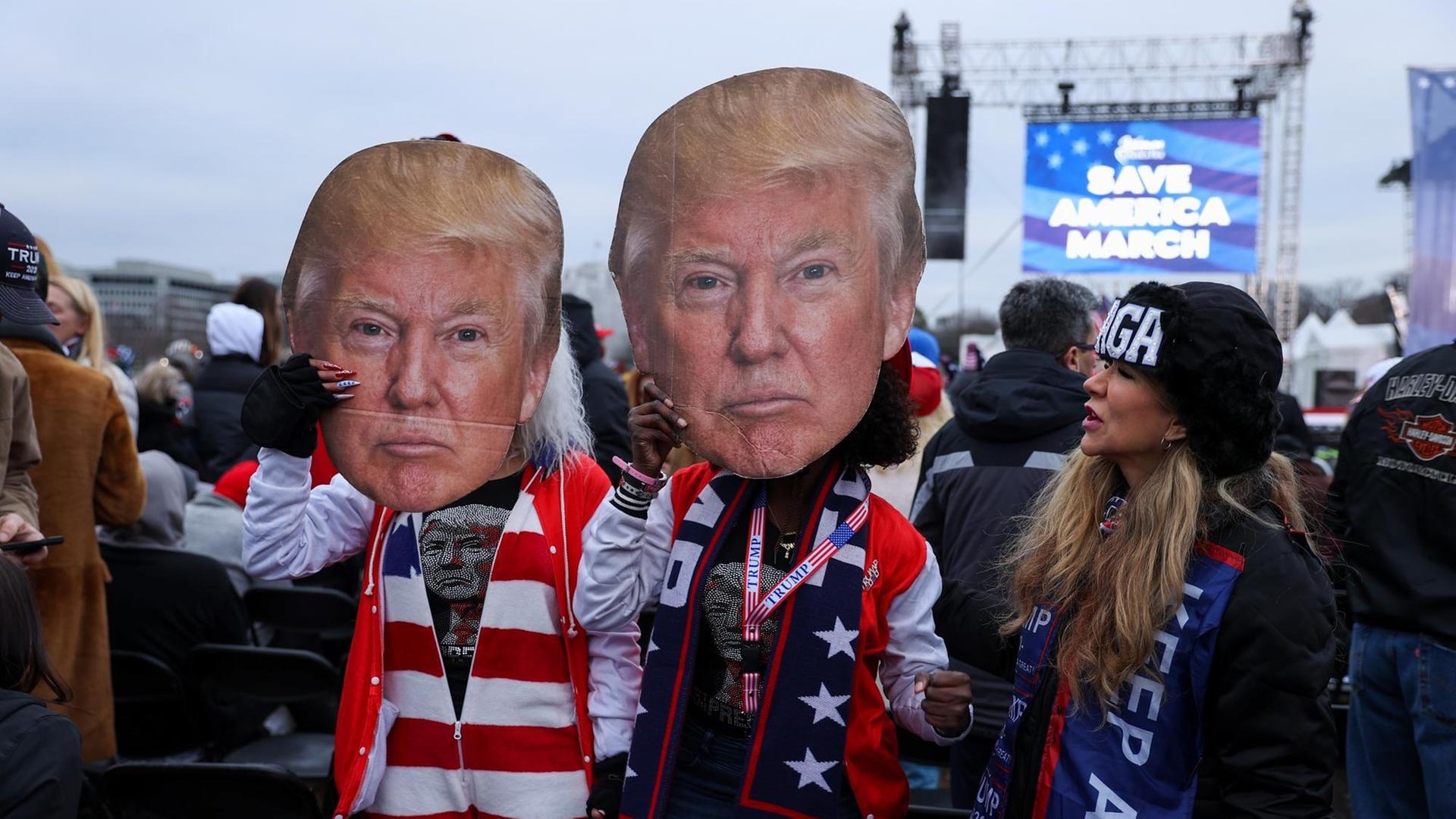 Mehrere Protestierende mit Trump-Masken stehen nahe dem Weißen Haus. Mehrere Protestierende mit Trump-Masken stehen nahe dem Weißen Haus.