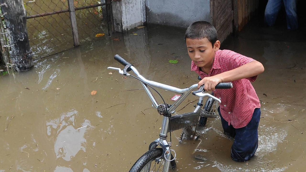 Ein Kind während einer Überschwemmung in Honduras - das Land hat mit vielen Extremwetterereignissen zu kämpfen. Ein Kind während einer Überschwemmung in Honduras - das Land hat mit vielen Extremwetterereignissen zu kämpfen.