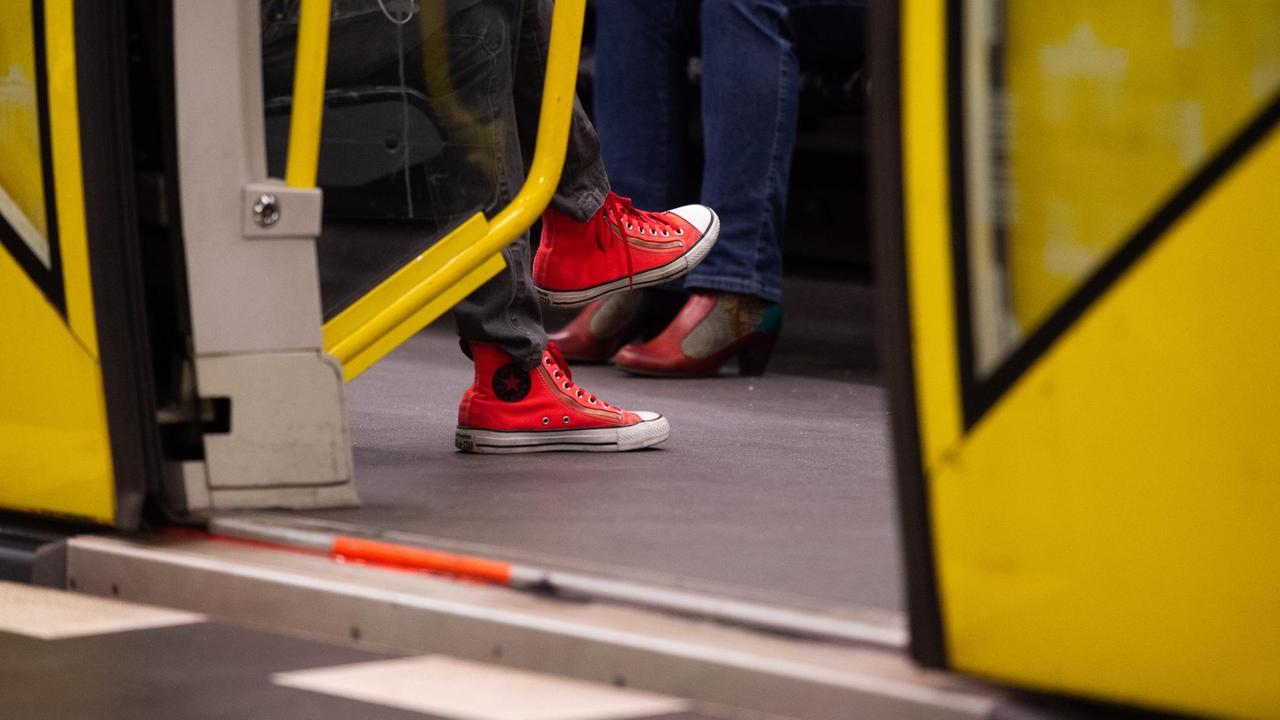 Eine Frau mit roten Schuhen sitzt in einer U-Bahn. Eine Frau mit roten Schuhen sitzt in einer U-Bahn.
