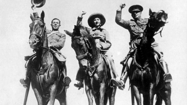 Rotspanische Kavalleristen kehren nach einem erfolgreichen Aufklärungsritt in ihre Stellung zurück (1936). Auf den drei Pferden sitzen zwei Männer und eine Frau.