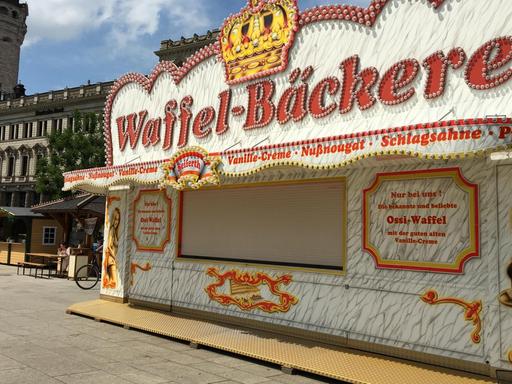Ein Waffel-Verkaufsstand auf dem Leipziger Stadtfest, der mit Frauen in Bikinis für sein Produkt wirbt.