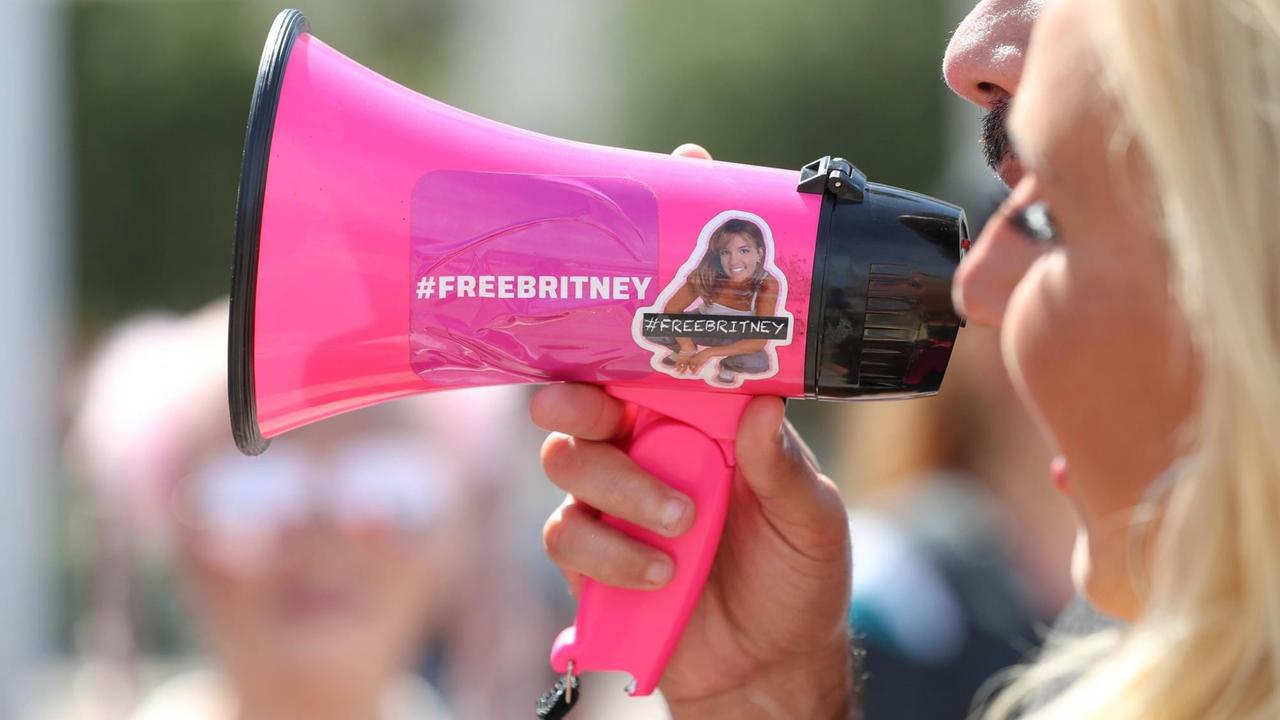 Zwei Menschen sprechen in ein rosa Megaphon, auf dem "Free Britney...</p>

                        <a href=
