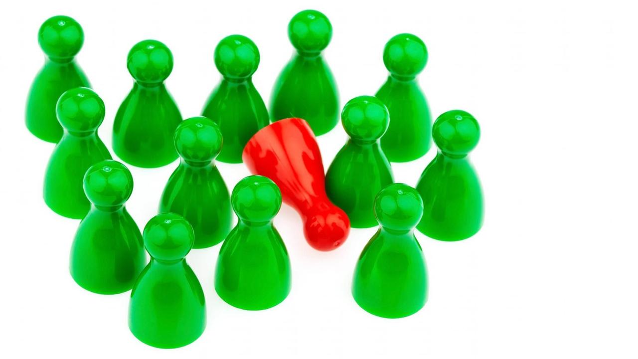 Symbolbild aus vielen grünen Spielfiguren, die um eine einzelne rote Spielfigur stehen.
