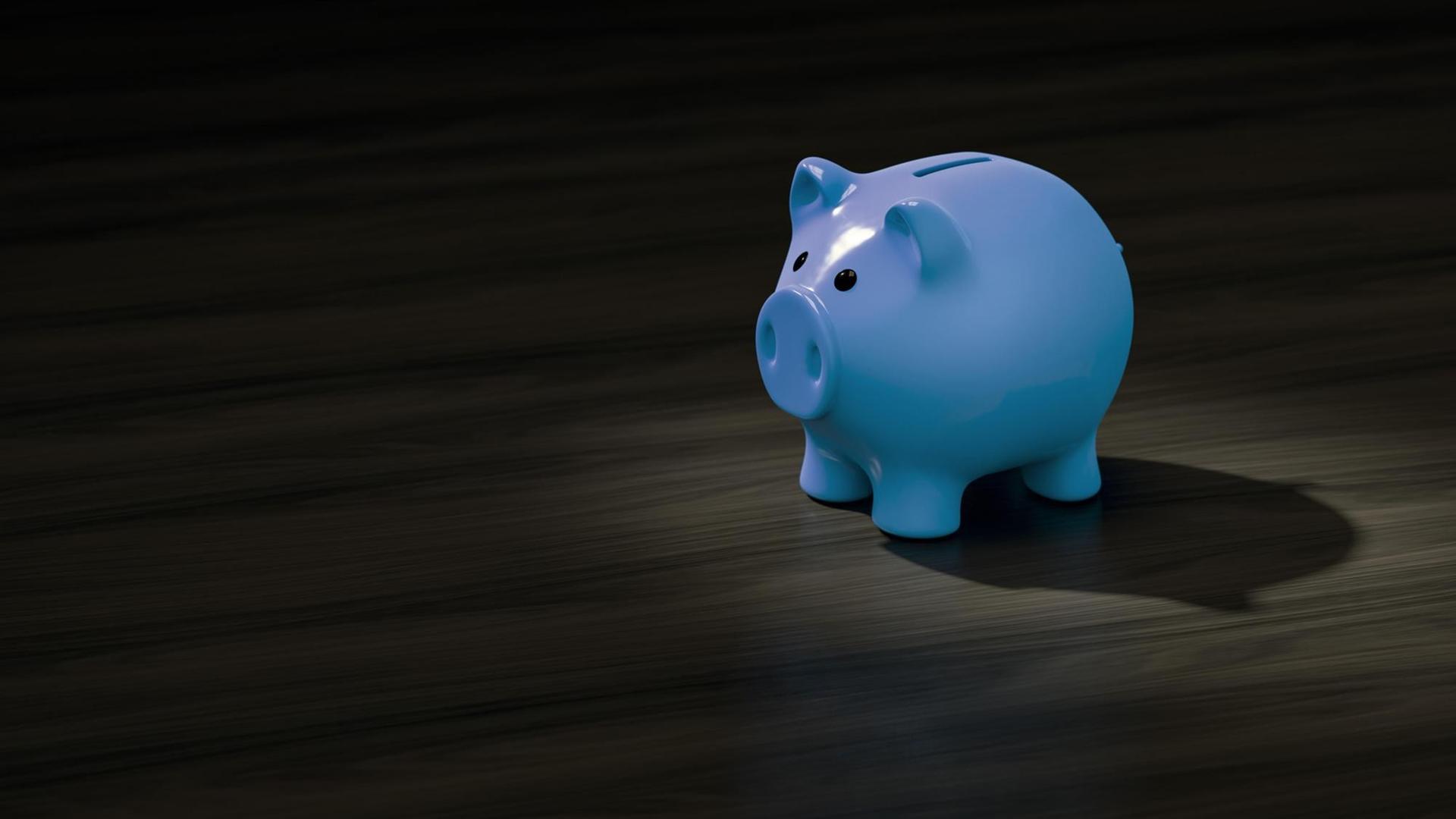 blaues Sparschwein auf schwarzem Hintergrund blaues Sparschwein auf schwarzem Hintergrund