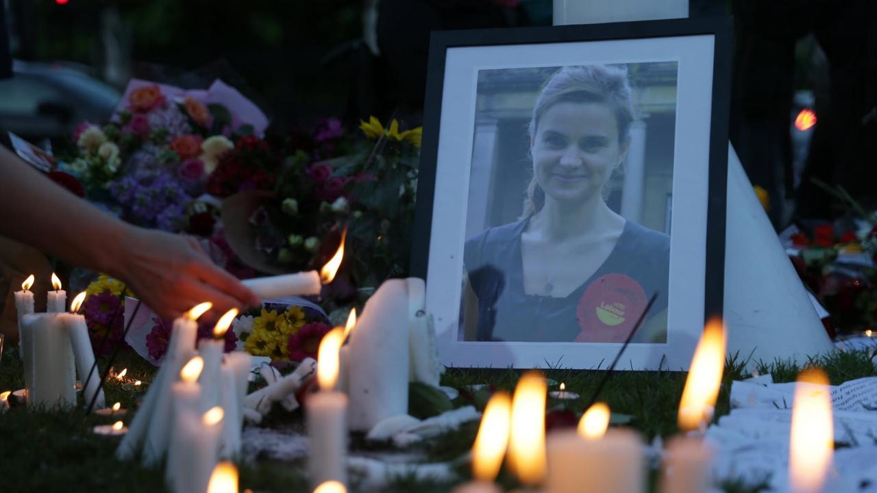 Kerzen brennen vor einem Bild der ermordeten britischen Politikerin Jo Cox.