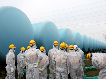 Mitglieder des japanischen Atomkraftregulierungsausschusses NRA inspizieren Behälter für kontaminiertes Wasser am havarierten Reaktor von Fukushima