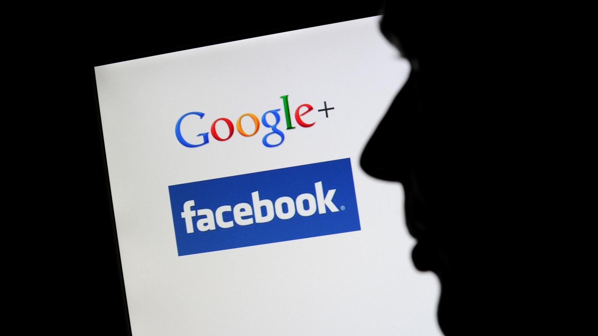 Die Silhouette eines Mannes zeichnet sich vor einem Computerbildschirm mit den Logos von Google+ und Facebook ab. Die Silhouette eines Mannes zeichnet sich vor einem Computerbildschirm mit den Logos von Google+ und Facebook ab.