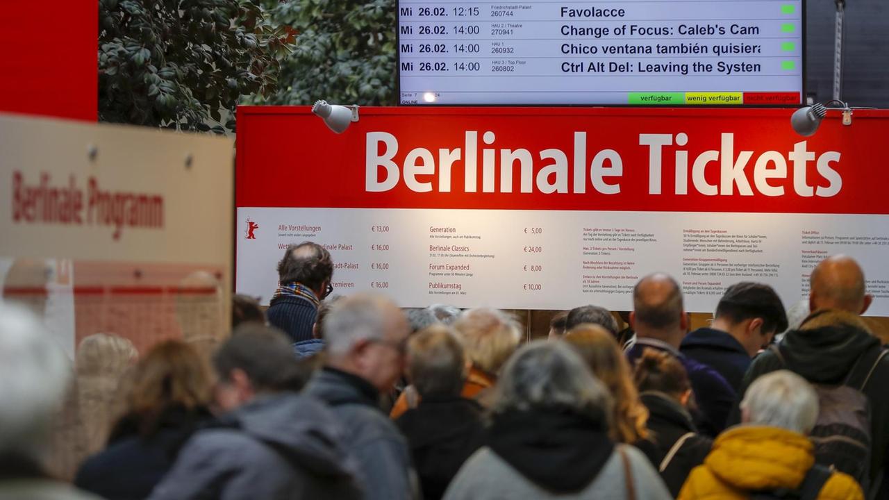 Menschen stehen an einem Verkaufsschalter für Berlinale-Tickets an