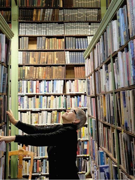 Eine Frau sucht zwischen den Regalen der Bibliothek in Leeds nach einem Buch.