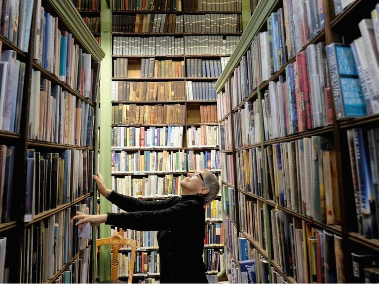 Eine Frau sucht zwischen den Regalen der Bibliothek in Leeds nach einem Buch.