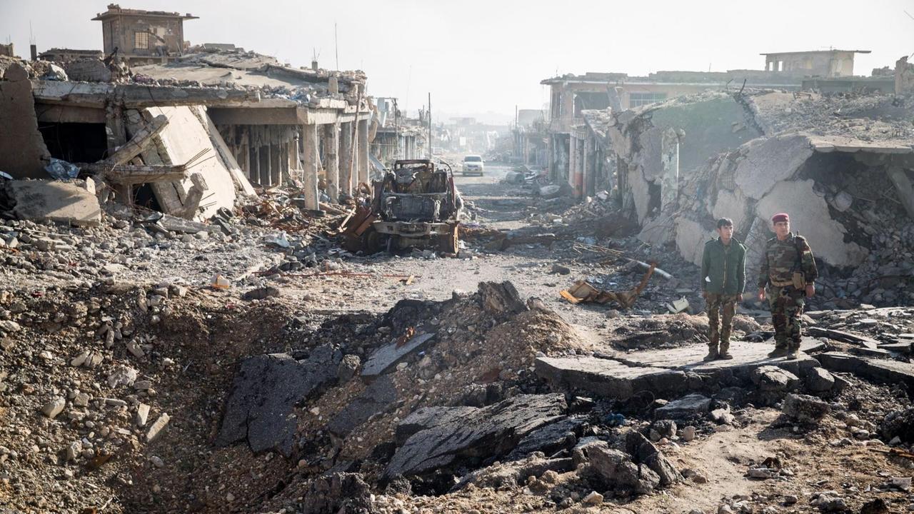 Syrische Soldaten stehen im Nordirak auf den Ruinen der iraktischen Stadt Sinjar.