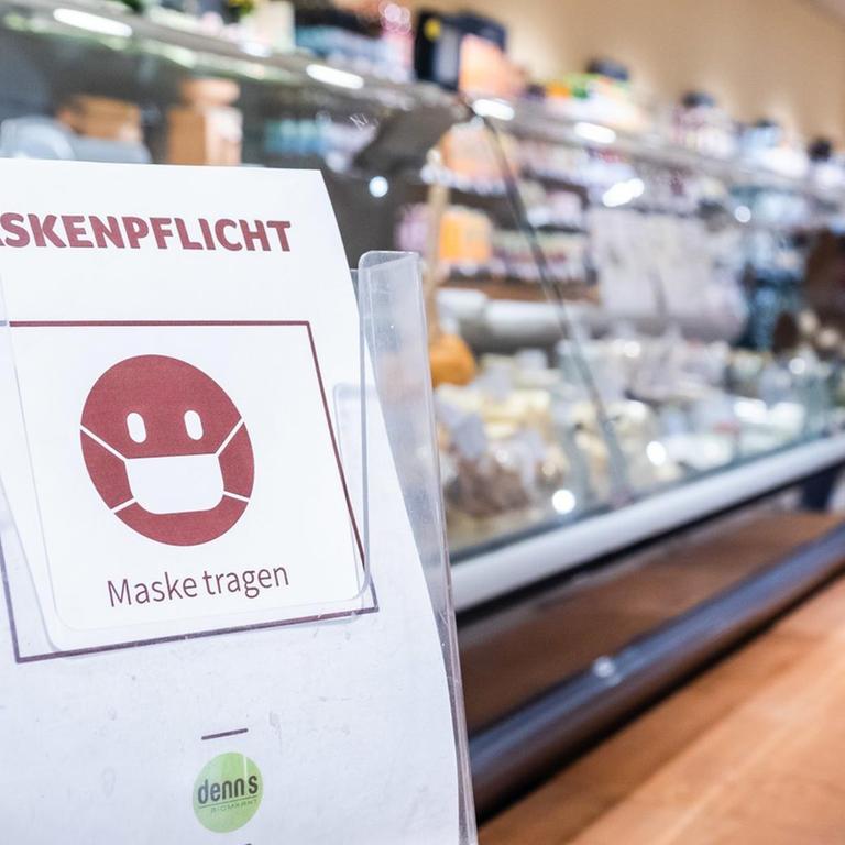 Schild mit Hinweis zur Maskenpflicht in einem Supermarkt.