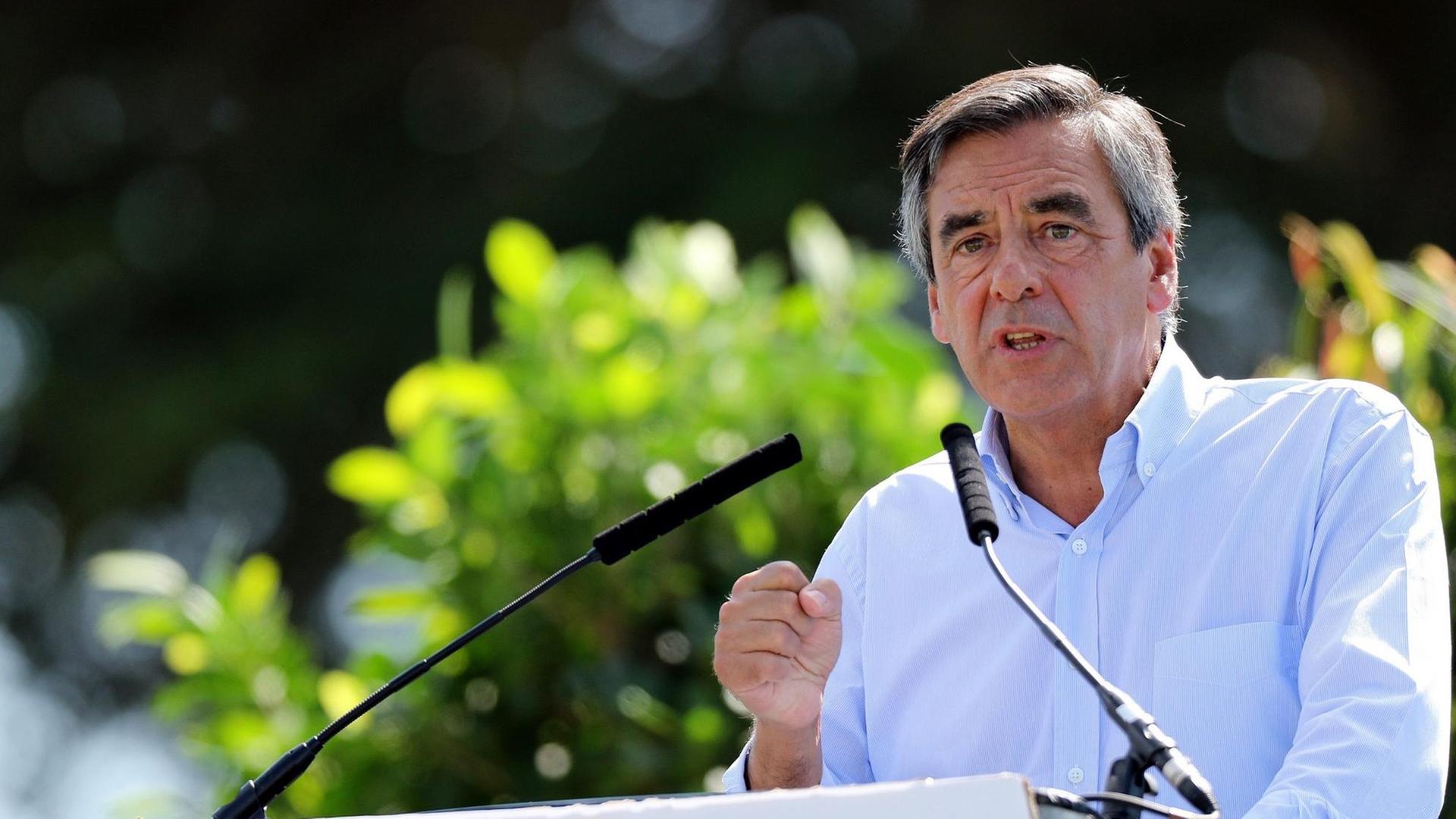 François Fillon steht an einem Sprecherpult und redet. François Fillon steht an einem Sprecherpult und redet.
