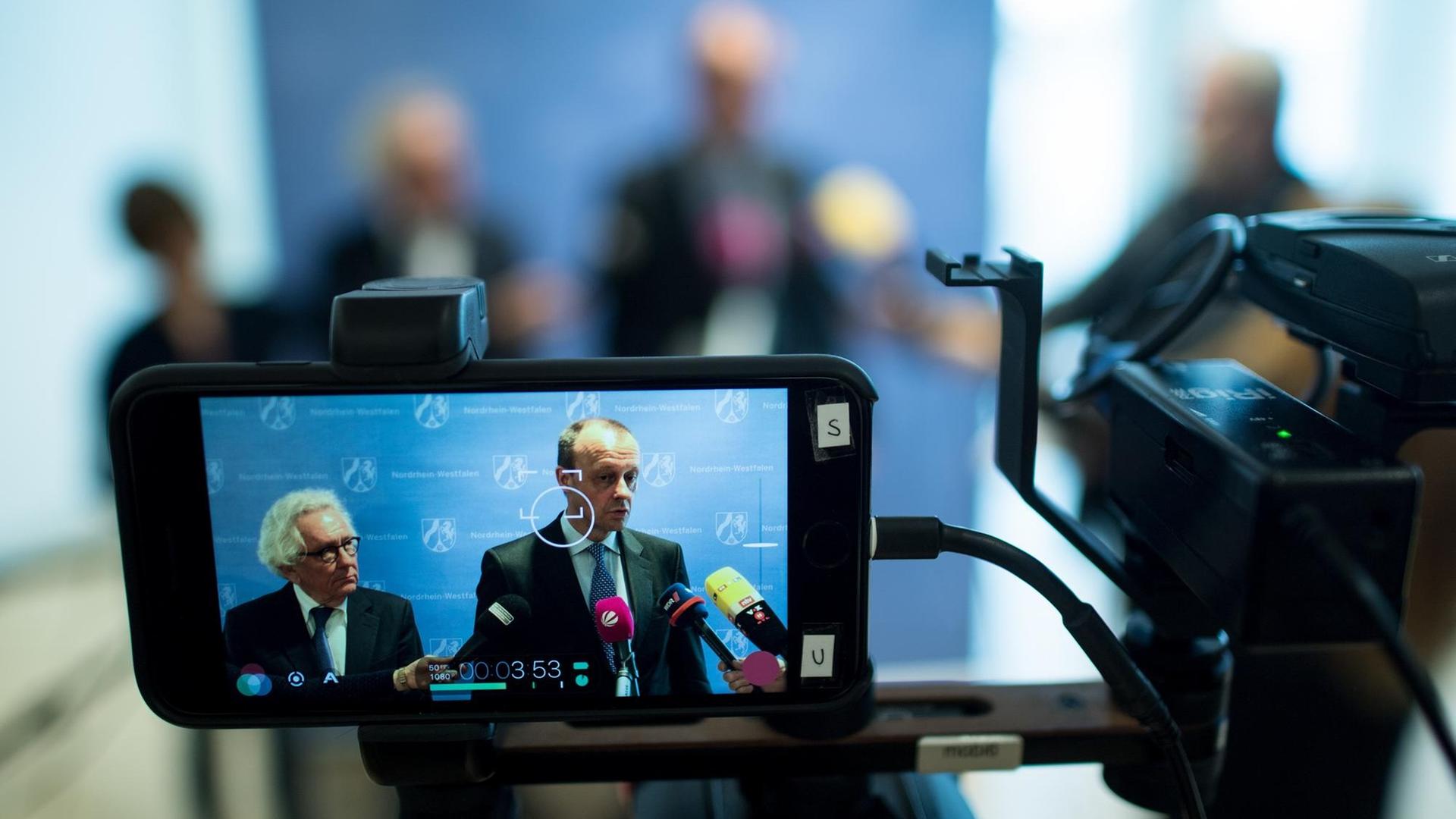 Friedrich Merz (CDU) spricht im März 2018 mit Journalisten im Landtag in Düsseldorf, zu sehen auf dem Display einer Kamera, die das Statement mitfilmt. Friedrich Merz (CDU) spricht im März 2018 mit Journalisten im Landtag in Düsseldorf, zu sehen auf dem Display einer Kamera, die das Statement mitfilmt.