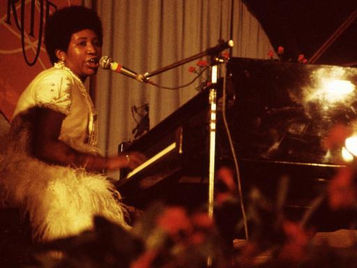 Aretha Franklin sitzt am Klavier und singt bei einem Festivalauftritt 1970.