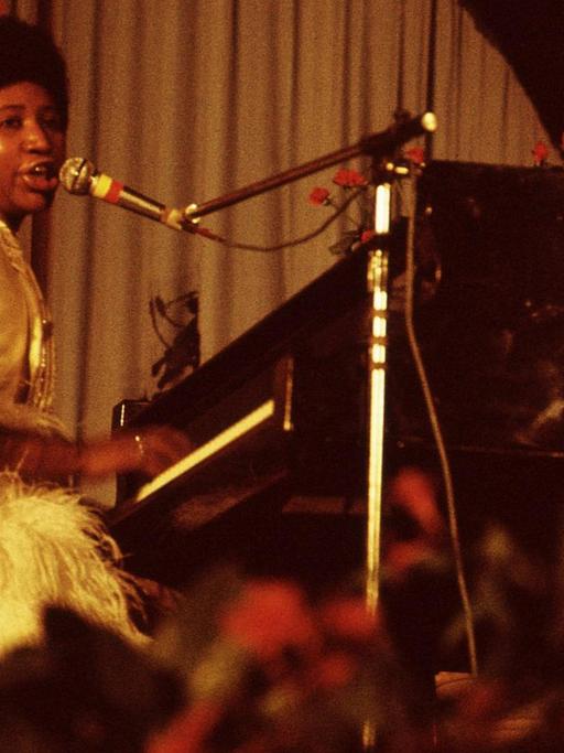 Aretha Franklin sitzt am Klavier und singt bei einem Festivalauftritt 1970.