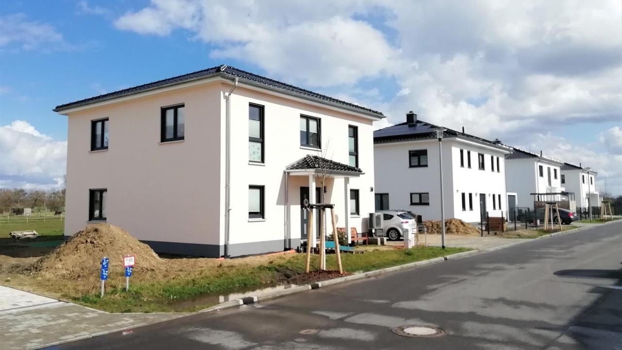 Mehrere neu gebaute Häuser, dahinter Wiesen und Äcker in der Neubausiedlung "Wiesenblick" in Dallgow-Döberitz im Landkreis Havelland in Brandenburg
