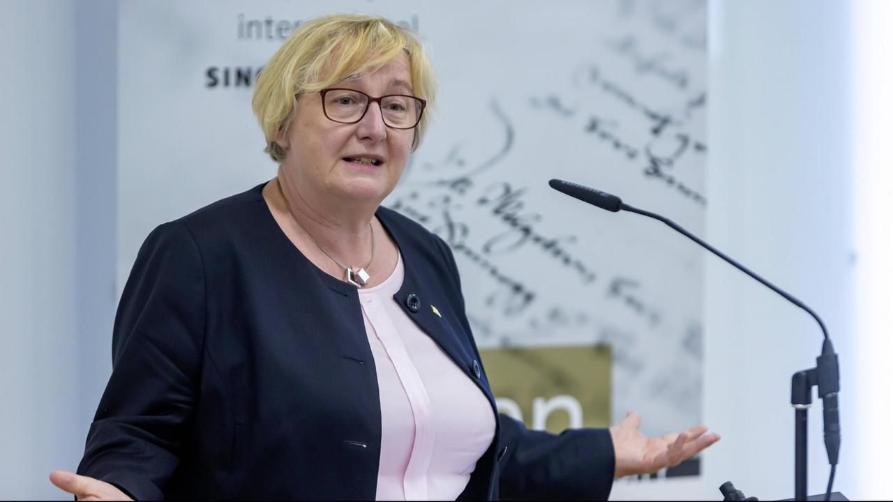 Die Wissenschaftsministerin von Baden-Württemberg, Theresia Bauer, ist zu sehen. Sie trägt ein dunkles Jacket und breitet die Arme aus. Die Wissenschaftsministerin von Baden-Württemberg, Theresia Bauer, ist zu sehen. Sie trägt ein dunkles Jacket und breitet die Arme aus.