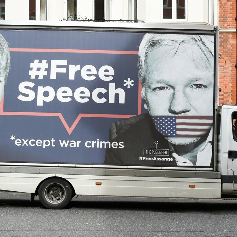 Ein Transporter mit einem Aufdruck der Gesichter von Julian Assange und Chelsea Manning steht vor der Botschaft Ecuadors in London