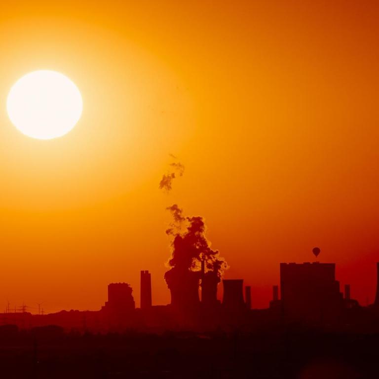 Das Kraftwerk Neurath von RWE vor einem roten Abendhimmel. 