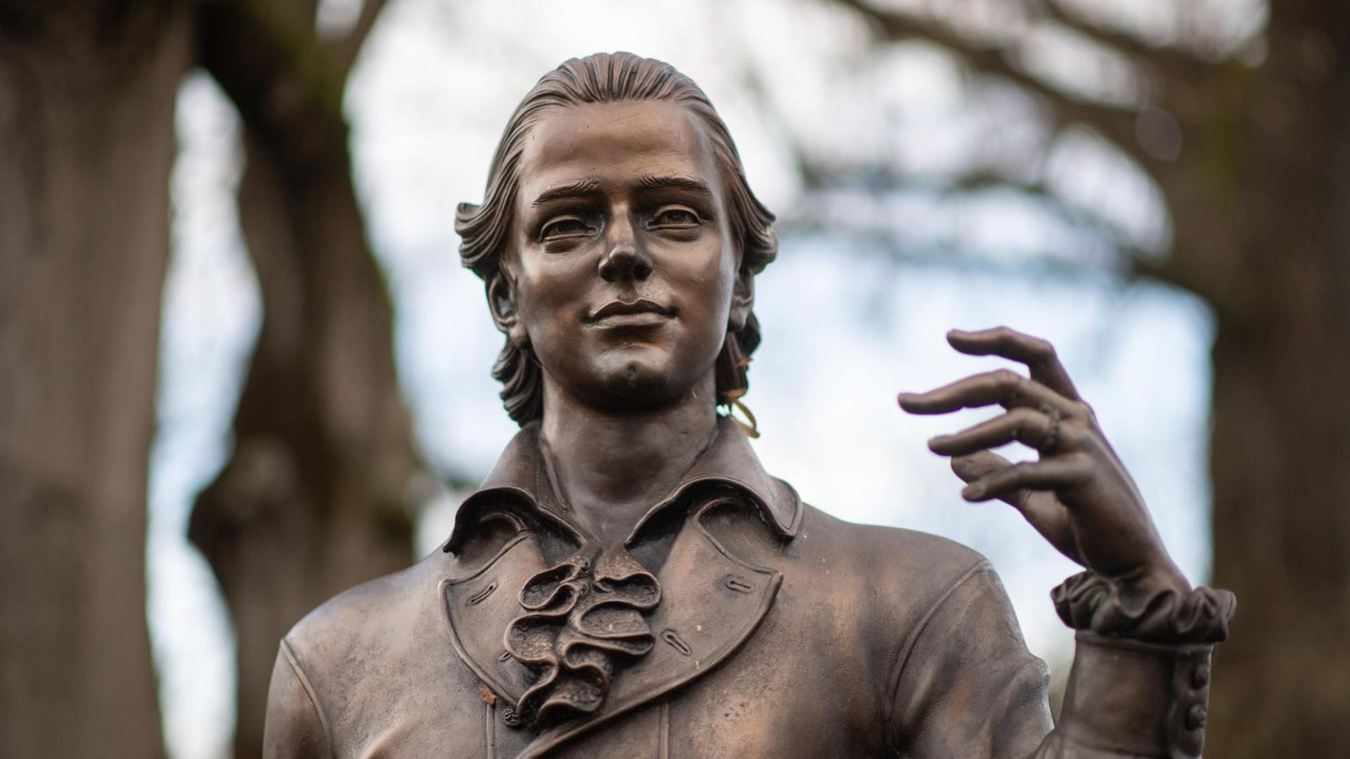Eine Skulptur des Künstlers Waldemar Schröder, die Friedrich Hölderlin darstellt, steht vor Bäumen. Eine Skulptur des Künstlers Waldemar Schröder, die Friedrich Hölderlin darstellt, steht vor Bäumen.