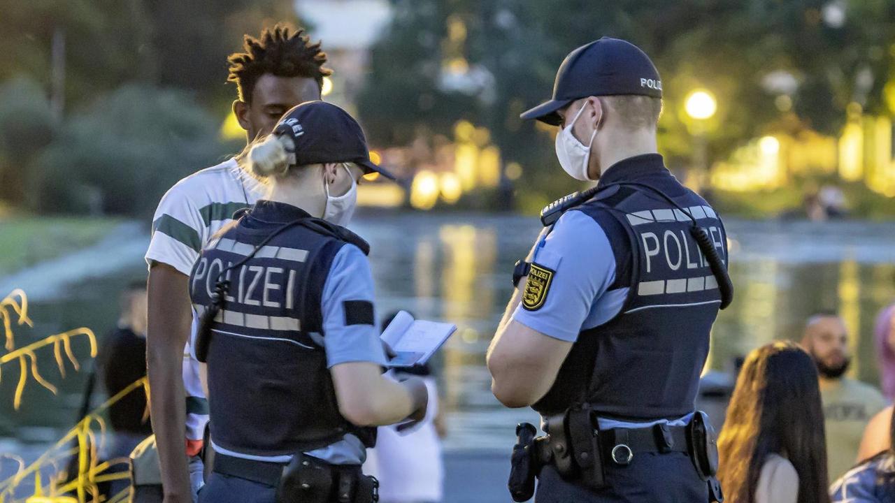 Zwei Polizisten kontrollieren eine Person während der Krawalle in Stuttgart. Zwei Polizisten kontrollieren eine Person während der Krawalle in Stuttgart.