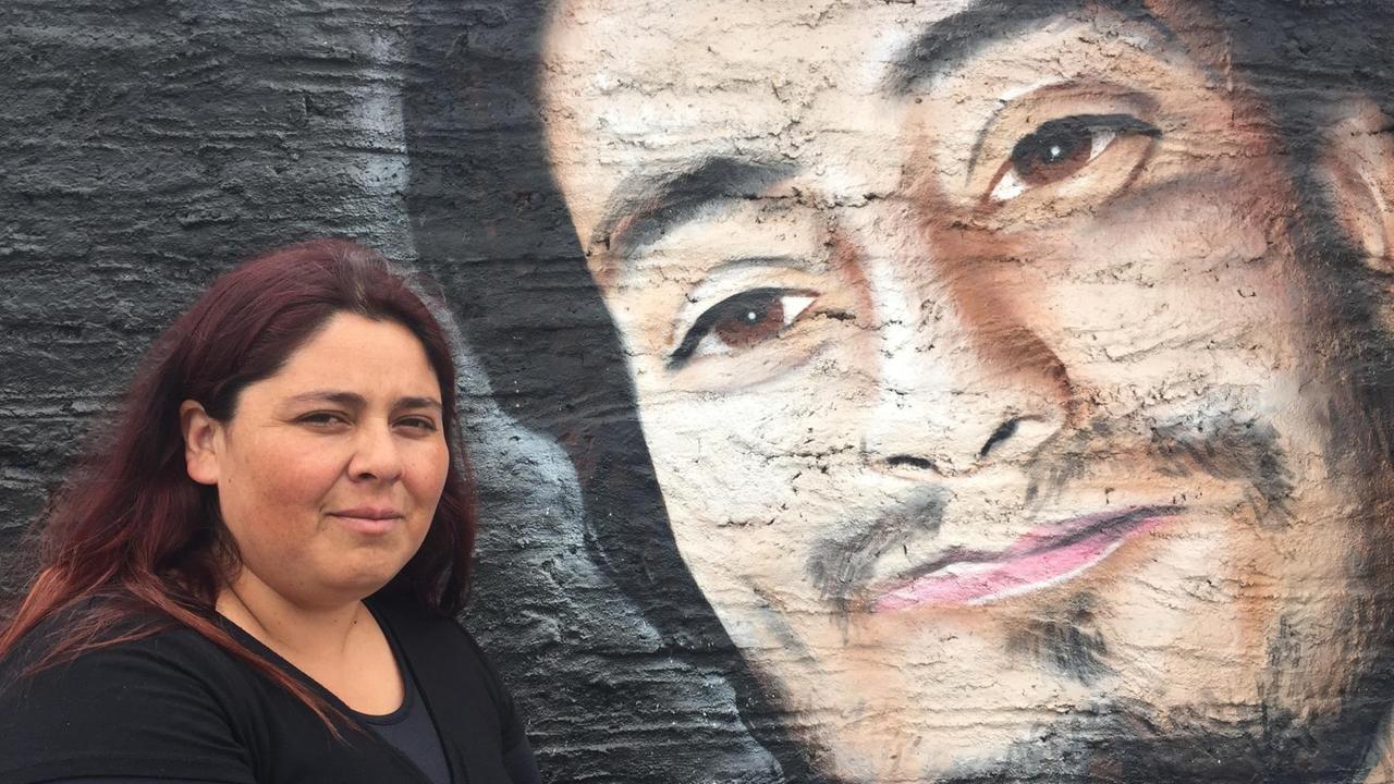 Natalia Perez steht links vor dem Graffiti-Bild ihres lächelnden Mannes, der bei den Protesten ums Leben kam.