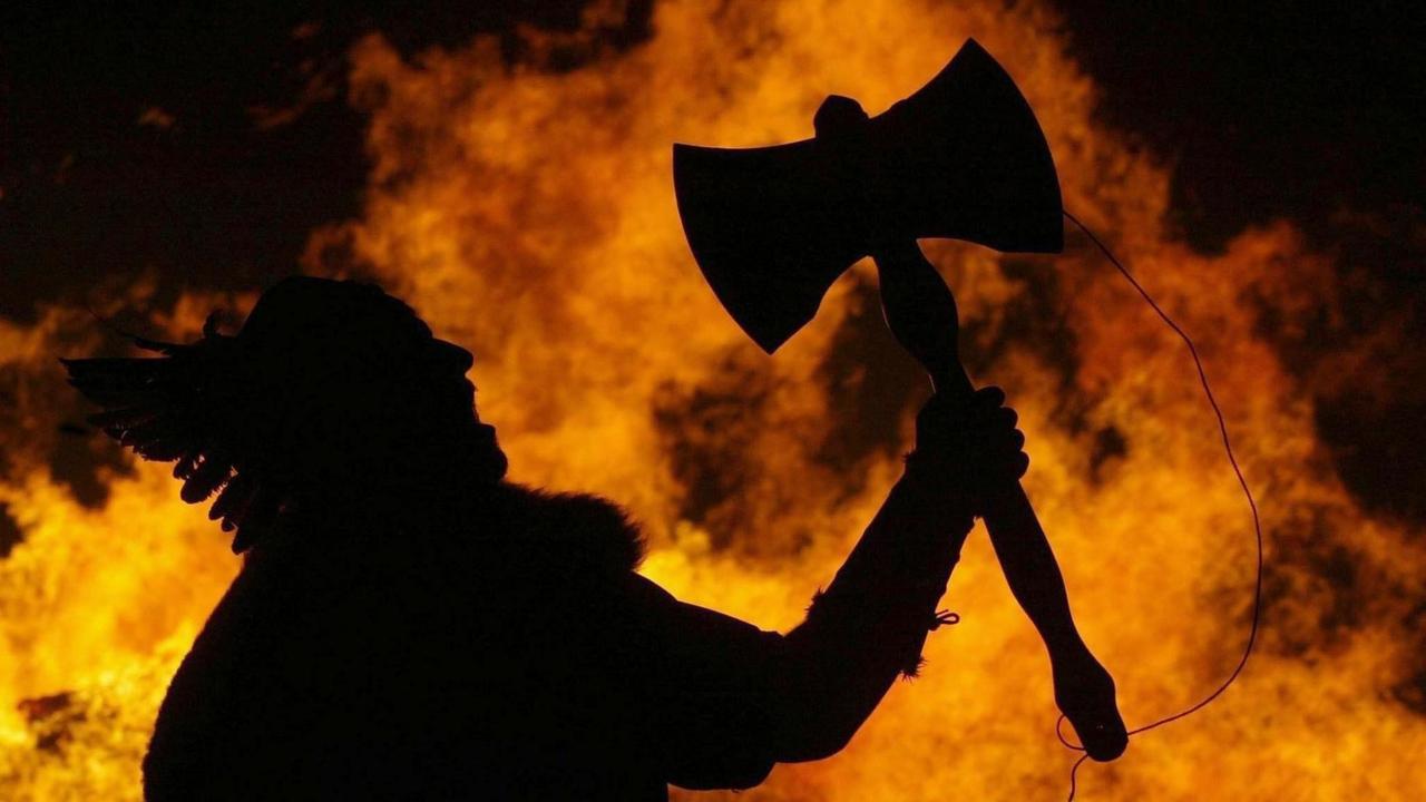 Ein Wikinger mit Axt vor einem Feuer auf einer Party 2004 in Edinburgh, Schottland. Ein Wikinger mit Axt vor einem Feuer auf einer Party 2004 in Edinburgh, Schottland.