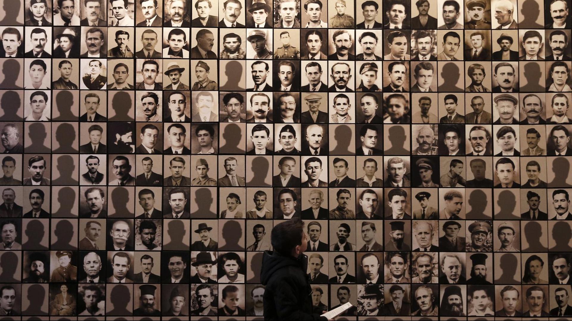 Ein Junge betrachtet am 21.3.2015 im Holocaust-Museum der griechischen Stadt Kalavryta die Porträts von Opfern des Massakers, das Wehrmachtssoldaten dort am 13. Dezember 1943 verübt haben. Ein Junge betrachtet am 21.3.2015 im Holocaust-Museum der griechischen Stadt Kalavryta die Porträts von Opfern des Massakers, das Wehrmachtssoldaten dort am 13. Dezember 1943 verübt haben.