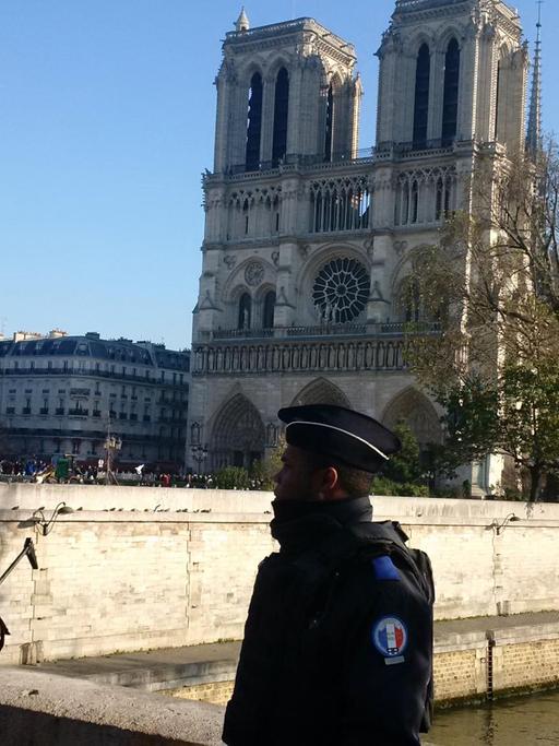 Zwei Polizisten stehen vor Notre-Dame in Paris.