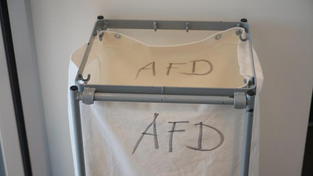 Ein Mülleimer mit def Aufschrift AfD steht vor dem Fraktionssaal der AfD im Deutschen Bundestag bereit.