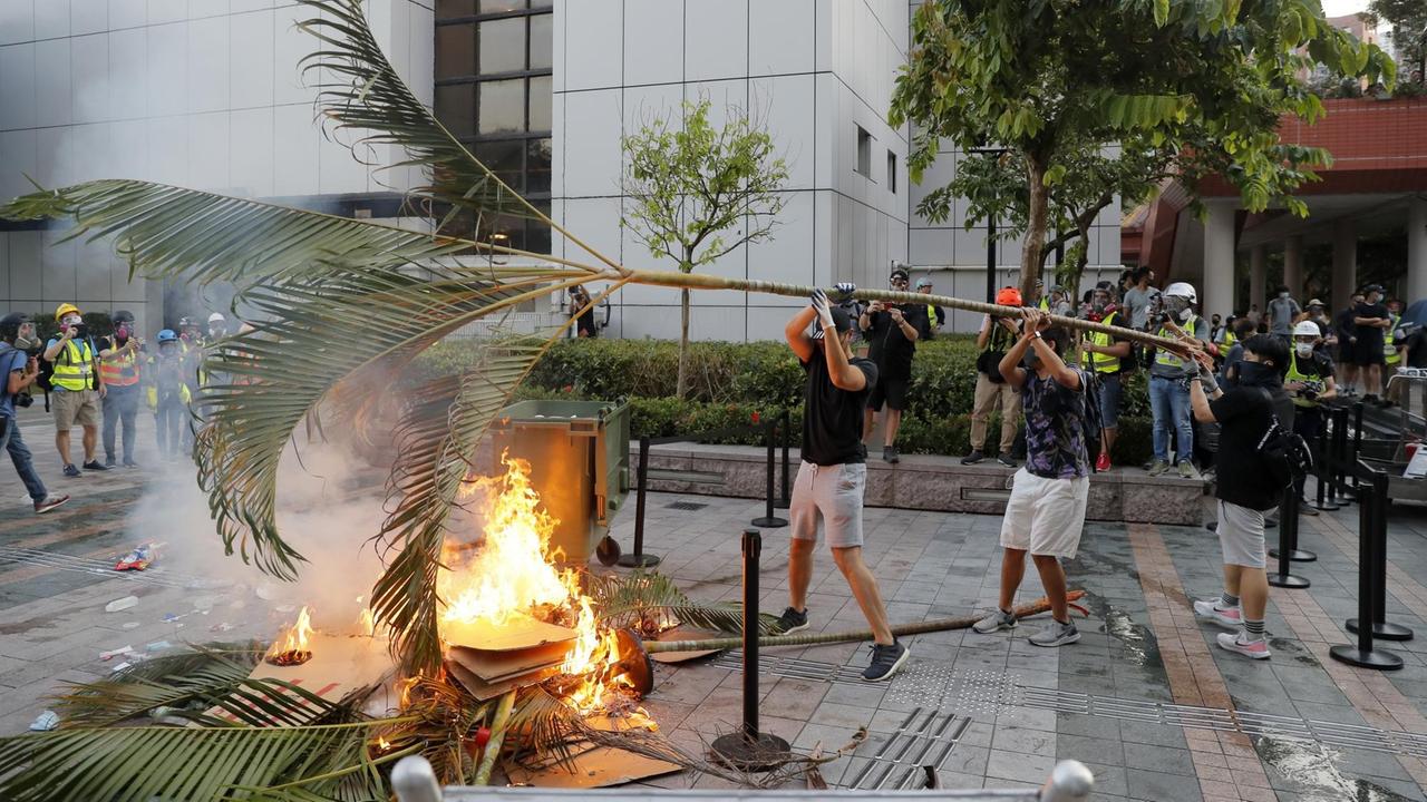 Demonstranten in Hongkong verbrennen Holz und Abfälle, um eine Straße zu blockieren.