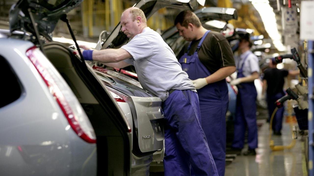 PKW-Produktion: Arbeiter montieren Autos.
PKW-Produktion: Arbeiter montieren Autos.