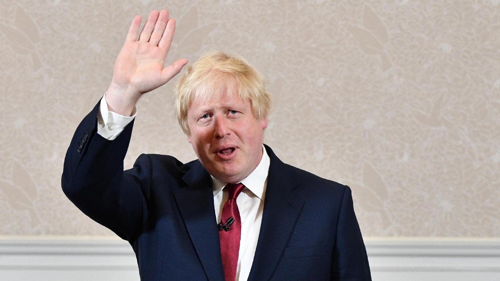 Der frühere Londoner Bürgermeister Boris Johnson winkt in die Kamera.