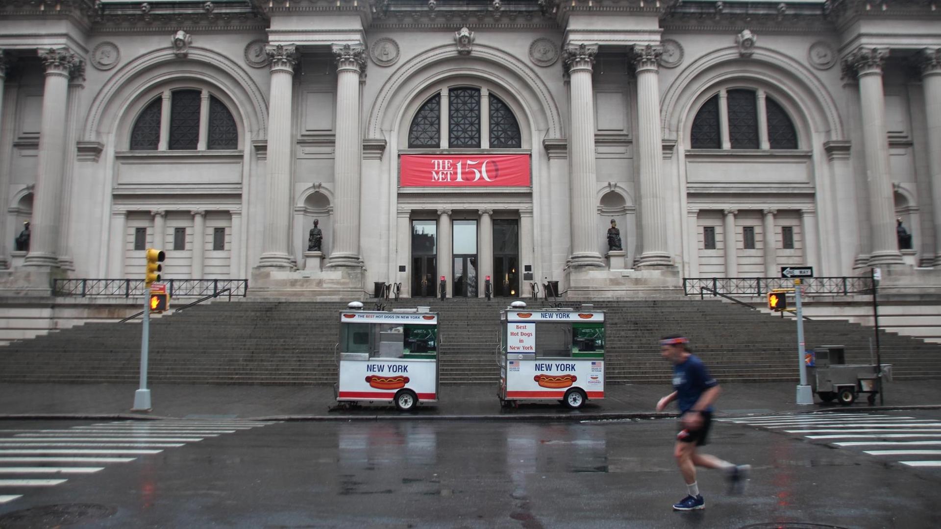 Ein Jogger läuft vor dem Eingang zum Metropolitan Museum auf der leeren Straße von New York (USA). Ein Jogger läuft vor dem Eingang zum Metropolitan Museum auf der leeren Straße von New York (USA).