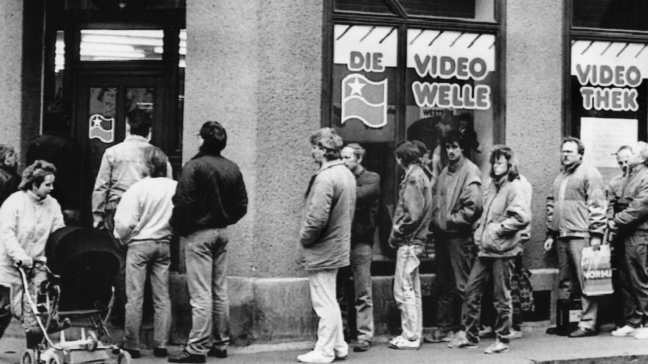 Kunden stehen im März 1990 in einer langen Warteschlange vor einer neueröffneten Videothek in Leipzig. Kunden stehen im März 1990 in einer langen Warteschlange vor einer neueröffneten Videothek in Leipzig.