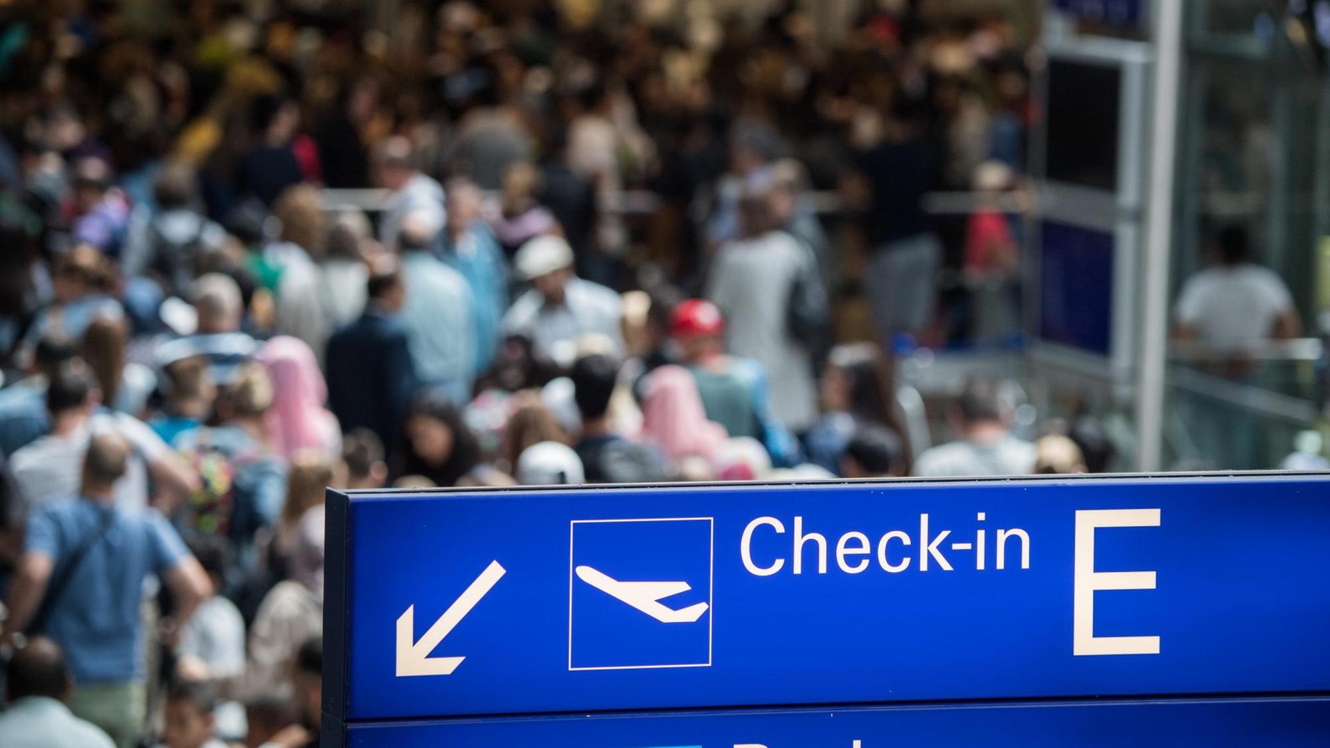 Reisende stehen in einer langen Schlange vor der Sicherheitskontrolle im Terminal 2 des Flughafens in Frankfurt am Main Reisende stehen in einer langen Schlange vor der Sicherheitskontrolle im Terminal 2 des Flughafens in Frankfurt am Main