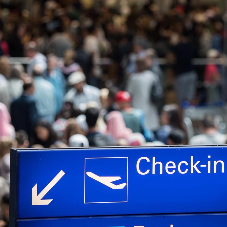 Reisende stehen in einer langen Schlange vor der Sicherheitskontrolle im Terminal 2 des Flughafens in Frankfurt am Main