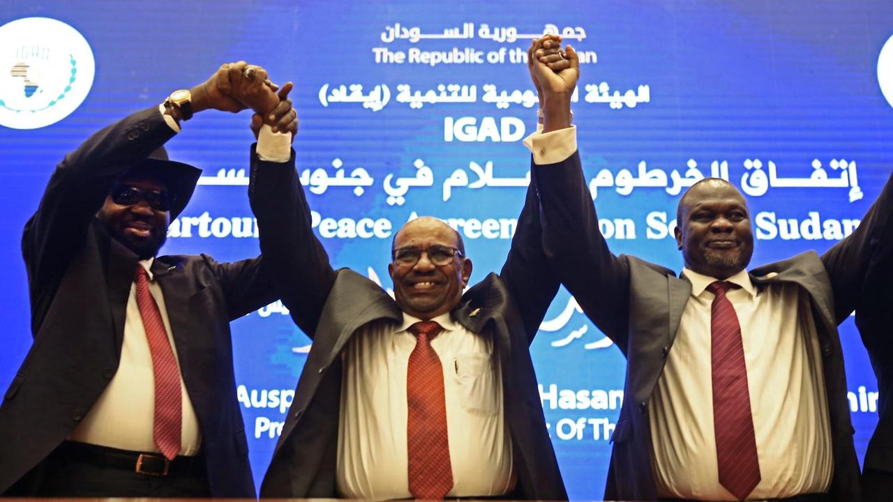 Der sudanesische Präsident Omar al-Bashir (Mitte) erhebt sich mit dem südsudanesischen Präsidenten Salva Kiir Mayardit (links) und dem südsudanesischen Rebellenführer Riek Machar (rechts), nachdem die beiden südsudanesischen Erzfeinde am 27. Juni 2018 der "Khartoum Declaration" zugestimmt hatten.