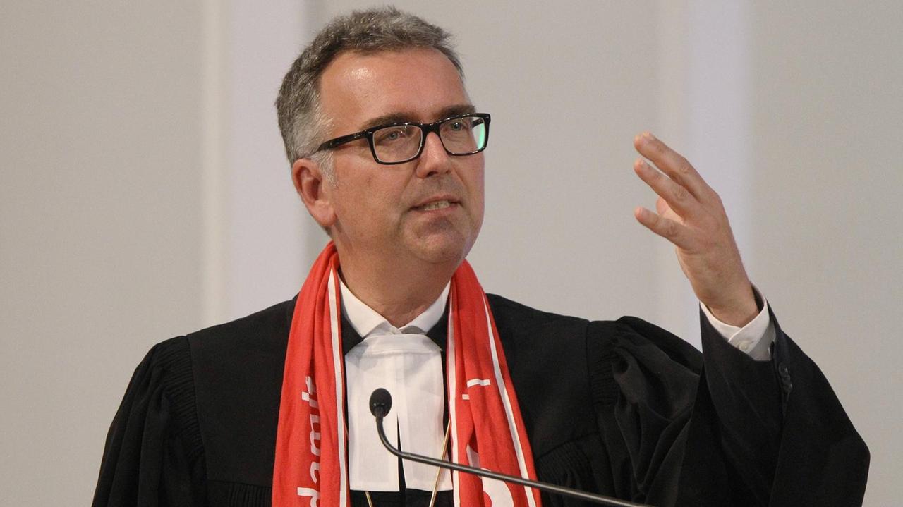 Der evangelische Militaerbischof Sigurd Rink predigt in einem schwarzen Talar an einem Pult. Der evangelische Militaerbischof Sigurd Rink predigt in einem schwarzen Talar an einem Pult.