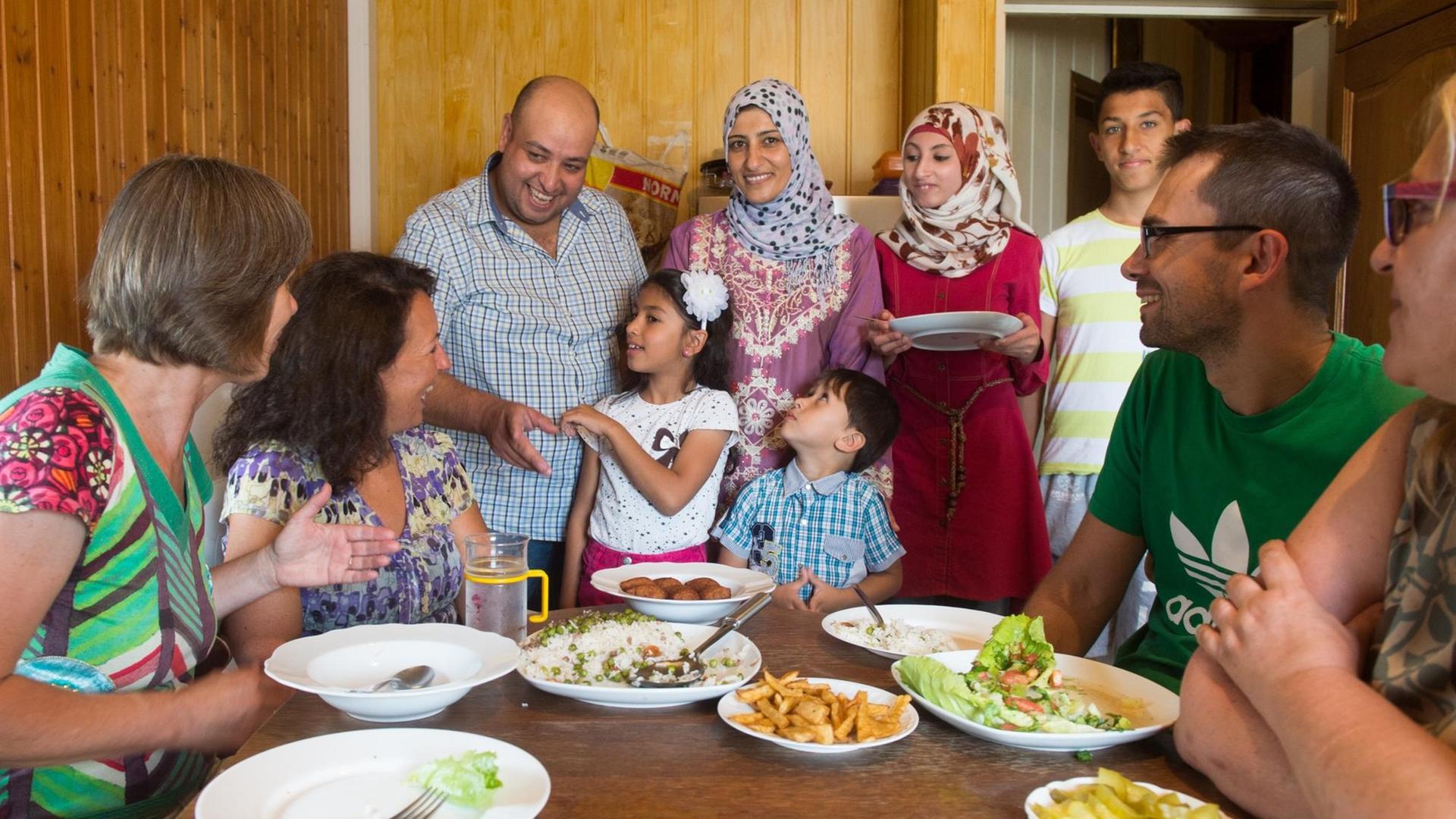 Der Syrer Walid Al Ali (3. v. l.) spricht am 03.08.2016 in Mangolding (Bayern) neben seiner Familie mit Helfern. Der 38-Jährige ist glücklich mit dem Dorfleben in der Oberpfalz. Der Syrer Walid Al Ali (3. v. l.) spricht am 03.08.2016 in Mangolding (Bayern) neben seiner Familie mit Helfern. Der 38-Jährige ist glücklich mit dem Dorfleben in der Oberpfalz.