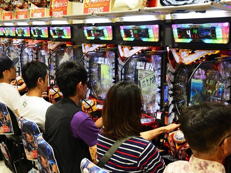 Japaner spielen Pachinko in einer Spielhalle, in Tokio