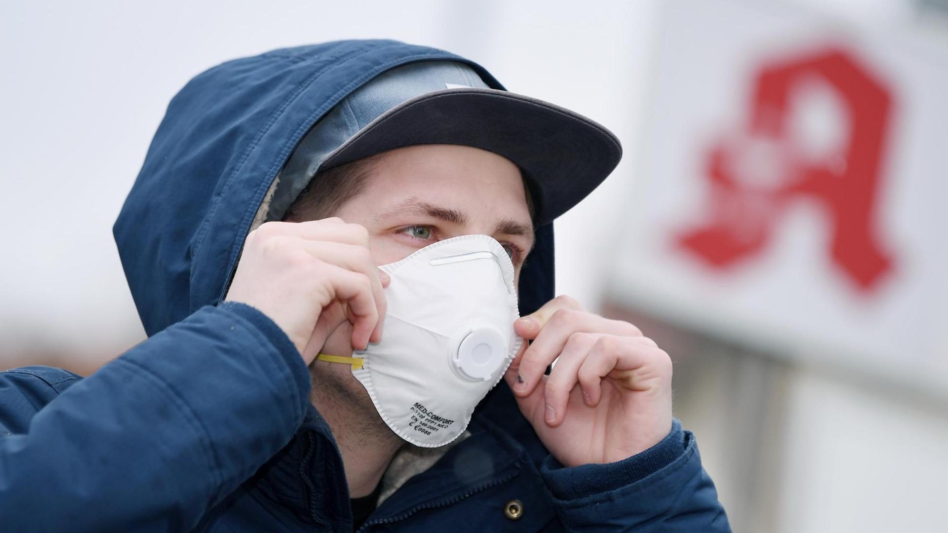 Ein Mann mit einer Schutzmaske vor einer Apotheke, Schutzmasken sind fast ausverkauft. Ein Mann mit einer Schutzmaske vor einer Apotheke, Schutzmasken sind fast ausverkauft.