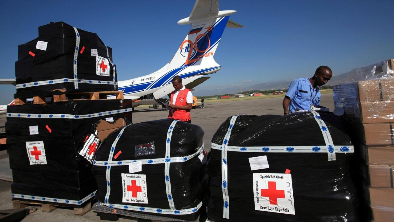 Zwei Männer mit Material einer spanischen NGO auf einem Flughafen bei Port au Prince, Haiti. Zwei Männer mit Material einer spanischen NGO auf einem Flughafen bei Port au Prince, Haiti.